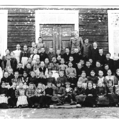 April 2007 Ett skolkort från 1895 i Örträsk Avskrift från tidningsurklipp från VK, troligen infört någon gång på 1960-talet: Örträsk gamla skola.  Bilden som insänts av Jonas Oskar Eriksson, Stöckeby, visar 1895 års elever vid Örträsk gamla skola i Östra Örträsk. två klassrum hade den men rymde ändå bara "storskola" och "lillskola". Folkskolläraren hette Wiklund och småskollärarinnan, Hulda Andersson. I första och andra raden, något till vänster på bilden (se markeringarna) återfinnes Eriksson själv, samt hans blivande fru, Agnes Näslund. " Kommentarer av undertecknad, som har gjort den numrerade skissen: För några år sedan fick jag en kopia av originalfotot av J. O. Erikssons sondotter, Siv Eriksson-Marklund, och det har gjort att ytterligare några elever kunnat identifieras. Nr 5. Jonas Oskar, nr 20. Agnes, nr 16. Edit Strömgren, bröderna Örestigs mor (gift med Per Persson), Klara Perssons bror, nr 30. Elma Rehnman (dotter till handlanden Rehnman), nr 34. (i randig klänning),  Klara Persson (med tiden blev hon fotograf), nr 36.(t.h.) Emmy Hellgren (gift med Johan Königsson, V. Örträsk),  nr 39. och 40., systrarna Hedvig och Hilma Jonsson (Hilma blev lärarinna för klasserna 3 och 4 i samma skola), och nr 53, deras bror, Albert,  nr 57. Amanda Sjölund, (gift med Helmer Strandberg), nr 63. Nils Viktor Königsson. Lärarna bör vara nr 69 och 70. Betr. skolbyggnaden: Till det yttre är den fortfarande i stort sett oförändrad sedan den byggdes på 1860-talet, särskilt på baksidan, som man kan se av ett foto från sekelskiftet 1800-1900. På framsidan fanns separata entréer till de båda skolsalarna och längst till höger ingång till lärarnas bostäder, som med tiden blev obehövliga. Från 1913 placerades "småskolan" i den mindre byggnaden intill den stora  Under 1950-talet kom vinkelbyggnaden till, med gymnastiksal och med skolbespisningslokal. Då gjordes också en omfattande ombyggnad av interiören, med lokaler även på övervåningen och med en gemensam entré, längst till höger mot vinkelbyggnaden. Från början av 1990-talet fick barnen sin skollunch på restaurang Pärlan. Då fick förskolan sin plats i den tidigare skolbespisningen, efter att köket tagits bort. Efter nära 150 år blev vårterminens avslut, år 2005 Örträsk skolas sista. Därefter "bussas" barnen till Bjurholm, där högstadieeleverna redan sedan tidigare gått, alternativt även i Lycksele.                                                                                         December 2006 /Margareta Dahlgren