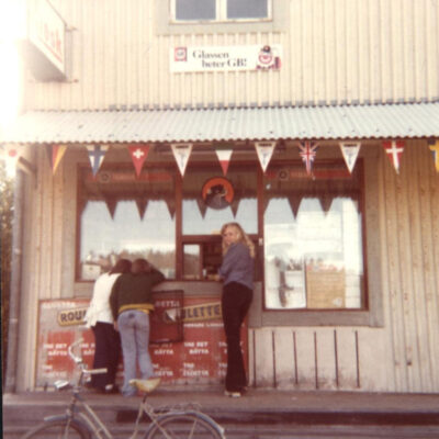 Augusti 2017 En bild från kiosken i Örträsk. Bilden är utlånad av Kari Hammer  Är det någon som har något att berätta om bilden hör av er till ake@runnman.se eller 070-282 00 02 eller skriv i kommentarsfältet här nedanför.  Från Charlotta Öhrman kommer följande:  Kiosken som låg i huset bredvid Sivs affär (Handlarn) ägdes av John och Betty Sandström fram till någon gång i början av 70-talet. John skötte också om minigolfbanan och i kiosken hämtade man ut klubbor och bollar för spel. Intill golfbanan stod den uppstoppade björnen, som numera finns på hembygdsgården. John och Betty drev tidigare under många år konditori och pensionat i huset. Betty Sandström hade dåtidens catering och gjorde bl.a. smörgåstårtor på beställning. Hos Sandströms kunde man också boka större fester och någon gång under min tonårstid serverade jag tillsammans med några kompisar på sådan fester.  Hälsn. Charlotta